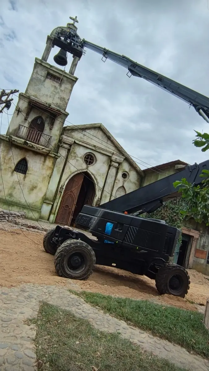 Manlift telescópico con cámara junto al campanario de un set de cine