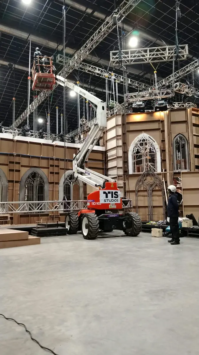 Manlift articulado extendido hacia el truss de un estudio de televisión
