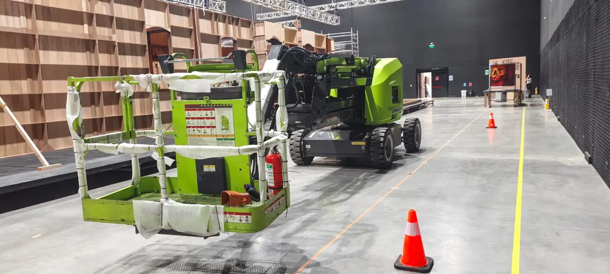 Manlift eléctrico con canasta protegida listo en un estudio