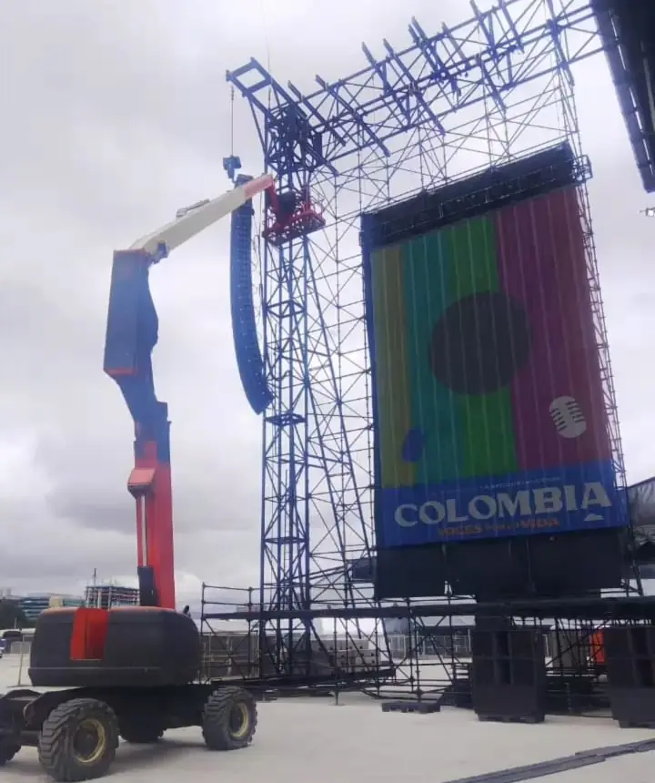 Manlift junto a la estructura de una tarima mientras se cuelga el sistema de sonido