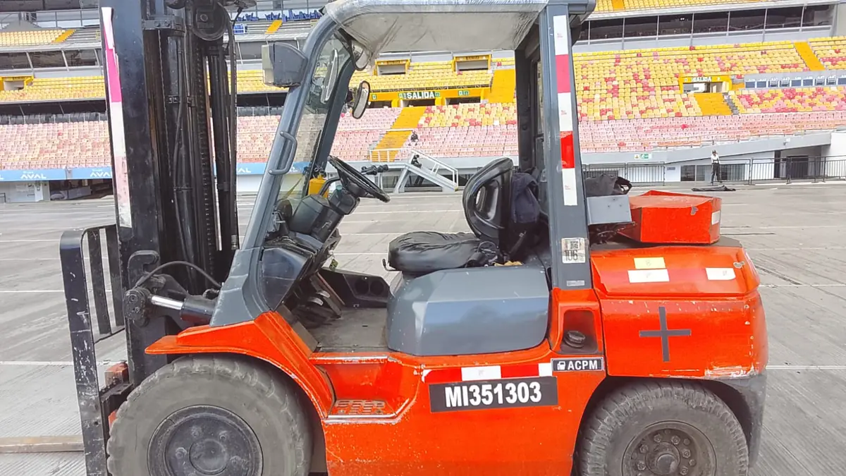 Montacarga sobre piso protegido en la cancha de un estadio