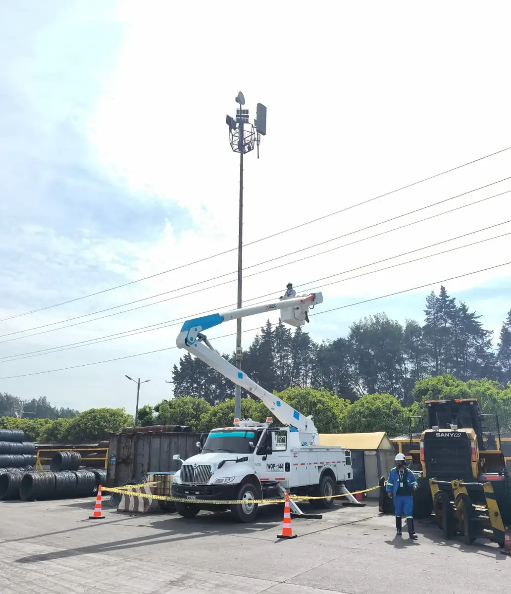 Carro canasta con operador en lo alto de un mástil de telecomunicaciones
